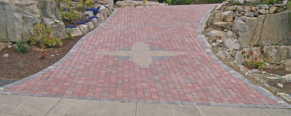 brick driveway with pattern and rock garden